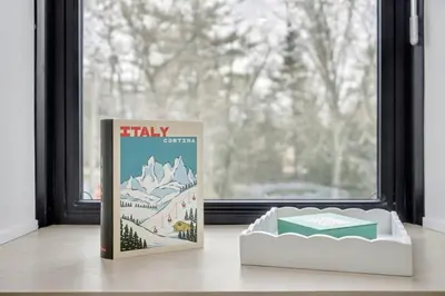 a book sitting on a table next to a window at The Wynford Dreamy Capri Suite in Elora