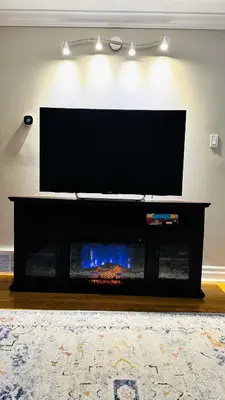 a flat screen tv sitting on top of a fireplace at 4-Bed, 3 bath Luxury Home in Oakville - Prime location in Oakville