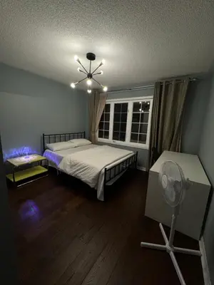 a bedroom with two beds and a fan and a window at Gorgeous Private room in Toronto
