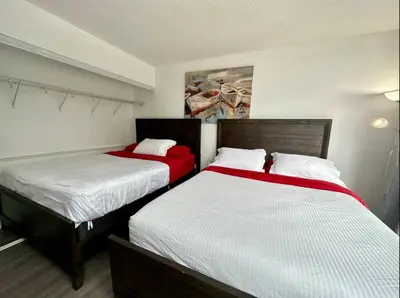 two beds in a hotel room with red and white sheets at Spacious two-bedroom abode in the heart of TO in Toronto