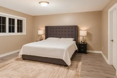 a bedroom with a large bed and two lamps at Spacious Brampton 4BR Upper Home in Brampton
