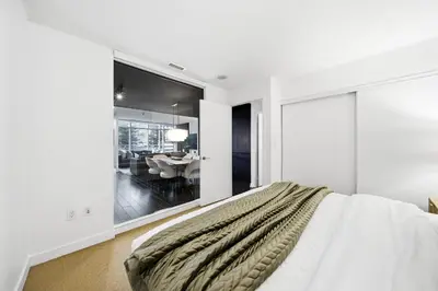 a white bedroom with a bed and a dining room at Luxury 4BR Home Sleeps 14 with Parking in Toronto