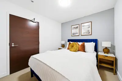 a bedroom with a large bed with a blue headboard at Luxury 4BR Home Sleeps 14 with Parking in Toronto