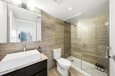 a bathroom with a toilet and a sink and a shower at Luxury 4BR Home Sleeps 14 with Parking in Toronto