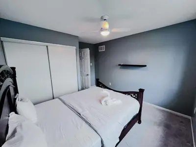 a small bedroom with a bed with white sheets at Family Comfort Retreat in Brampton