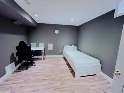 a bedroom with a bed and a desk and a chair at Family Comfort Retreat in Brampton