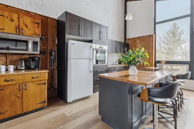 a kitchen with a white refrigerator and a table at 8 Bedroom Blue Mountain Chalet with Ping-Pong - 218 Arlberg in Blue Mountains