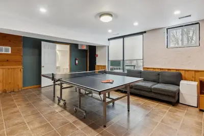 a ping pong table in a living room with a couch at 8 Bedroom Blue Mountain Chalet with Ping-Pong - 218 Arlberg in Blue Mountains