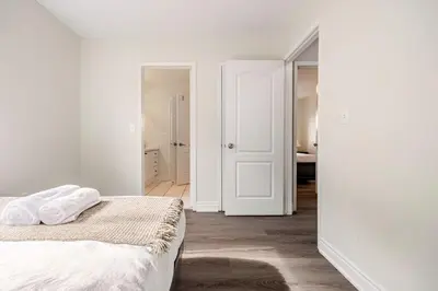 a bedroom with white walls and a bed with white sheets at Comfortable Brampton Getaway 3BR, 3BA, 4 Beds in Brampton