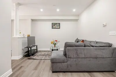 a living room with a gray couch and a fireplace at Comfortable Brampton Getaway 3BR, 3BA, 4 Beds in Brampton
