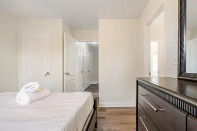 a bedroom with a bed and a dresser with a mirror at Comfortable Brampton Getaway 3BR, 3BA, 4 Beds in Brampton