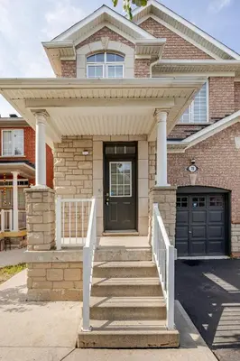 a brick house with a black door and stairs at Comfortable Brampton Getaway 3BR, 3BA, 4 Beds in Brampton
