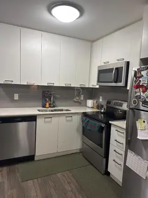 a kitchen with white cabinets and stainless steel appliances at One-Bedroom Apartment with Den With Amazing Views of Hamilton in Hamilton