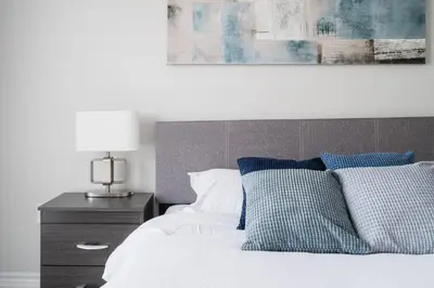 a bedroom with a bed with blue and white pillows at Airport/Family/3bdrm/5beds/4bath/Workspace/Hiking in Brampton