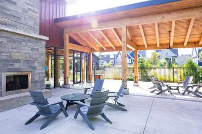 a patio with chairs and a table and a fireplace at Relaxing Spa Getaway, Sauna, Hot Tub & Heated Pool in Blue Mountains