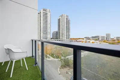 a balcony with a chair and a view of the city at Elegant 2BR Condo with 55 TV & City Views in Toronto