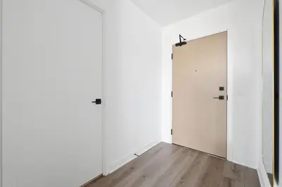an empty room with two doors and a wooden floor at Elegant 2BR Condo with 55 TV & City Views in Toronto
