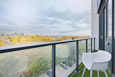 a balcony with a chair and a view of the city at Modern 3BR Condo Sleeps 8 with Floor-to-Ceiling Views in Toronto
