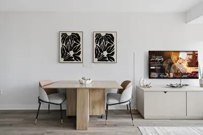 a dining room with a table and three pictures on the wall at Cozy 2BR Condo with Free Parking & City Views in Toronto