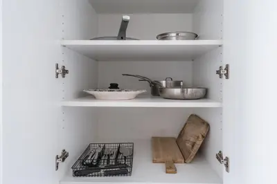 a kitchen with white shelves with cooking utensils at Stylish Modern Condo in the Heart of Toronto in Toronto