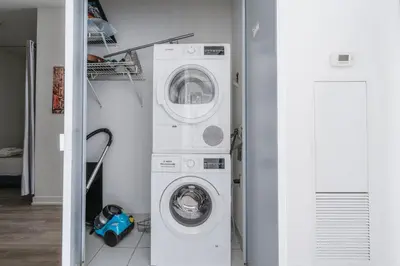 a laundry room with a washer and dryer at Stylish Modern Condo in the Heart of Toronto in Toronto