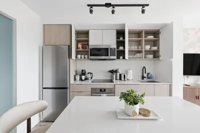 a kitchen with a table and a refrigerator at Modern West Getaway 2BR Condo with Free Parking in Toronto