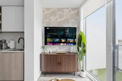 a kitchen with a flat screen tv on the wall at Modern West Getaway 2BR Condo with Free Parking in Toronto