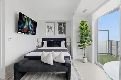 a bedroom with a bed and a tv on the wall at Skyline Studio with Stunning City Views & Parking in Toronto