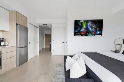 a bedroom with a bed with a tv on the wall at Skyline Studio with Stunning City Views & Parking in Toronto