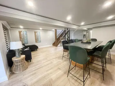 a living room with a dining room table and chairs at Cottage getaway in the city, for intimate family gathering in Ajax