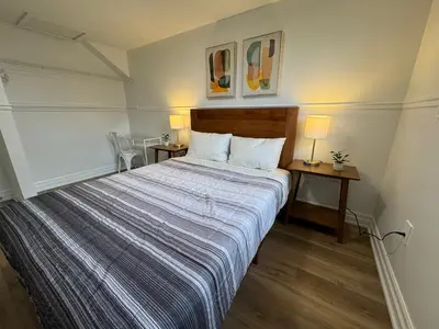a bedroom with a bed with two tables and two lamps at North Barrie !D Stylish and Cozy Private Bedroom with Shared Bathroom in Barrie