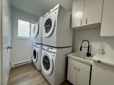 a laundry room with a washer and dryer next to a sink at North Barrie !D Stylish and Cozy Private Bedroom with Shared Bathroom in Barrie