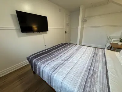 a bedroom with a bed with a flat screen tv on the wall at North Barrie !D Stylish and Cozy Private Bedroom with Shared Bathroom in Barrie
