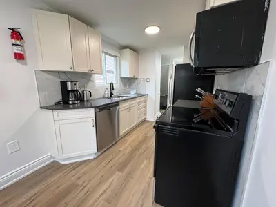 a kitchen with black appliances and white cabinets at North Barrie !D Stylish and Cozy Private Bedroom with Shared Bathroom in Barrie
