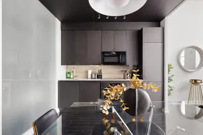 a kitchen with a glass table and black cabinets at Modern 4BR Home Sleeps 12 Steps to CN Tower in Toronto