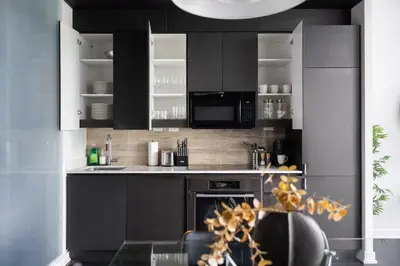 a kitchen with black cabinets and a stove at Modern 4BR Home Sleeps 12 Steps to CN Tower in Toronto