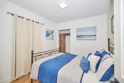 a bedroom with a bed with blue and white pillows at RIVERSIDE WALK in Niagara Falls