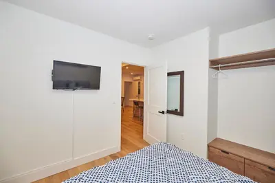 a bedroom with a bed and a tv on a wall at RIVERSIDE WALK in Niagara Falls