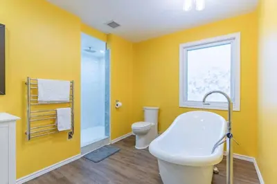 a bathroom with yellow walls and a toilet and a sink at Riverview Cottage Escape in Frankford