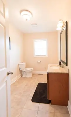 a bathroom with a toilet and a sink and a mirror at WALK TO THE BEACH in Fort Erie
