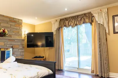 a bedroom with a bed and a large window at Elegant Mansion with Private Bar & Game Lounge in Mississauga