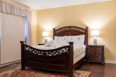 a bedroom with a large wooden bed with two lamps at Elegant Mansion with Private Bar & Game Lounge in Mississauga