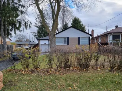 a house with a tree in a yard at Newly Renovated 3BR Upper Unit - Bright & Quiet in Richmond Hill