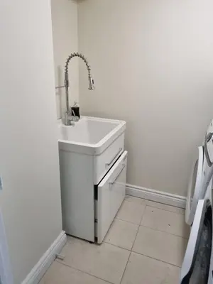 a white sink in a bathroom with a tiled floor at Newly Renovated 3BR Upper Unit - Bright & Quiet in Richmond Hill