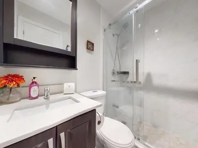 a bathroom with a shower and a toilet and a sink at Cozy Queen room with Shared Bath near Seneca Finch 404 in Toronto