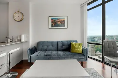 a living room with a couch and a large window at 1 Bedroom Condo Burano Downtown Toronto in Toronto