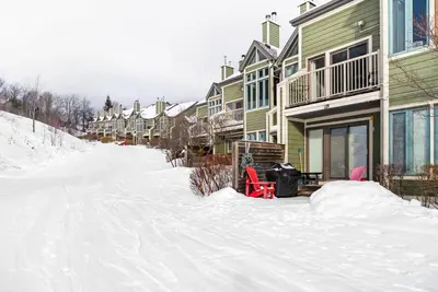 a snow covered street next to a row of houses at Hillside Hideaway Ski-In Ski-Out Walk to Village in Blue Mountains