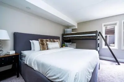 a bedroom with a large bed with a black headboard at Easy Rider Chalet Steps to Lift & Blue Village in Blue Mountains