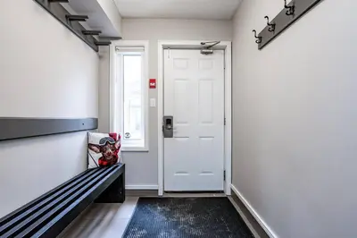 a hallway with a bench and a white door at Easy Rider Chalet Steps to Lift & Blue Village in Blue Mountains