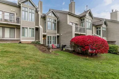 a large house with a red bush in front of it at Chateau Ridge Retreat - Ski-In Ski-Out Winter Fun in Blue Mountains